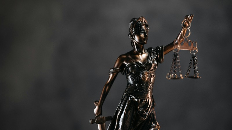 Detailed bronze Lady Justice statue with scales and sword against a dark background, symbolizing law and justice., tags: europäische human-rights-clinics: künftige - pexel